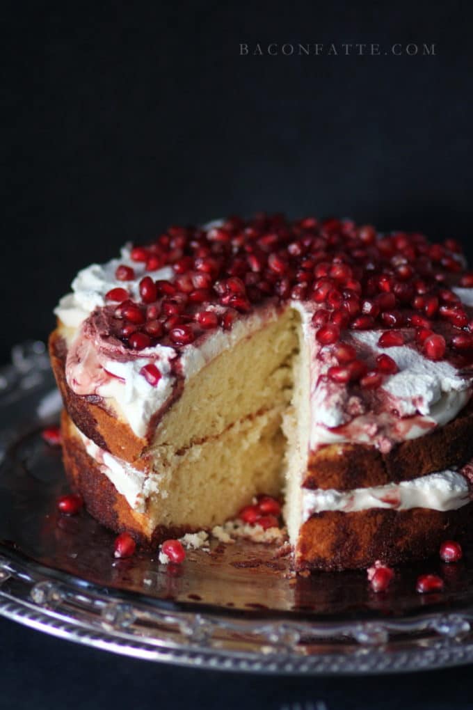 Amaretto Butter Cake topped with a whipped cream icing and pomegranate ariels.