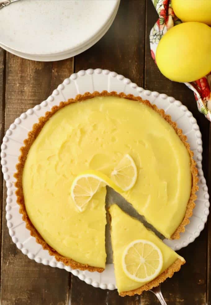 A lemon tart with a slice cut out. 