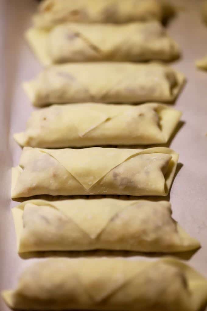 Wrapped and filled egg rolls ready to cook. 