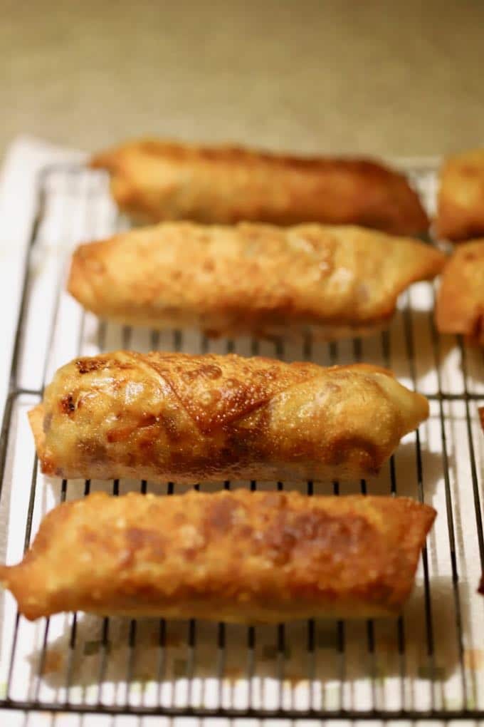 Fried egg Rrolls draining on a metal rack