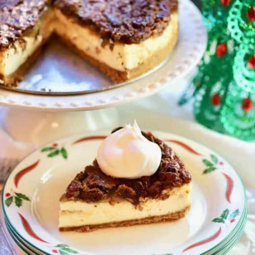 A slice of Southern Pecan Praline Cheesecake ready to serve with a dollop of whipped cream