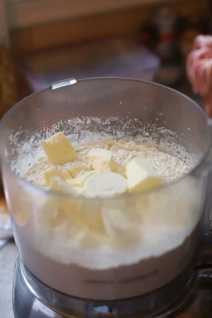 Adding butter to the food processor for Crispy Cheesy Southern Cheese Crackers