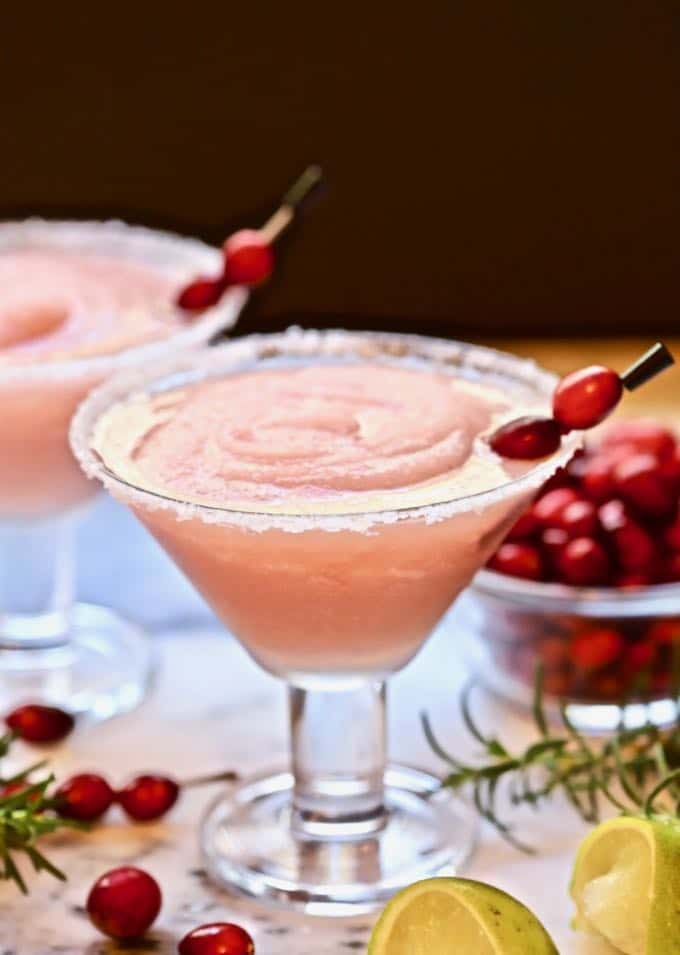 A frozen cranberry margarita with rosemary and fresh cranberries for garnish. 