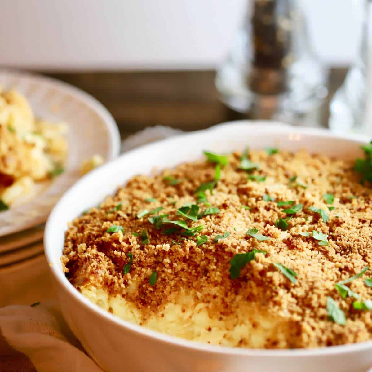 A mac and cheese casserole in a round white dish.