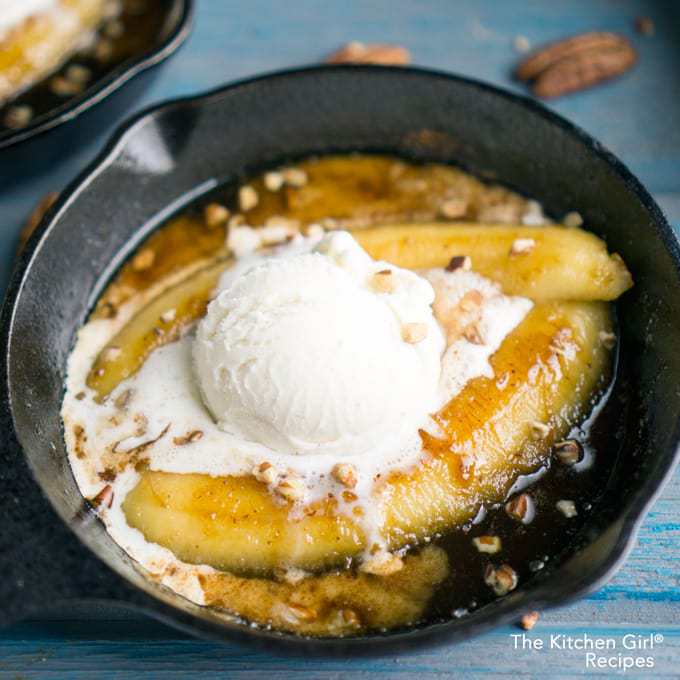 Bananas Foster in a cast iron skillet topped with a scoop of ice cream. 
