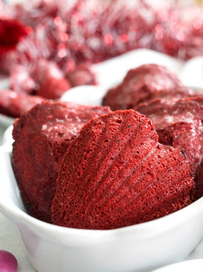 Red Velvet Madeleines in a white dish in the shape of a heart. 