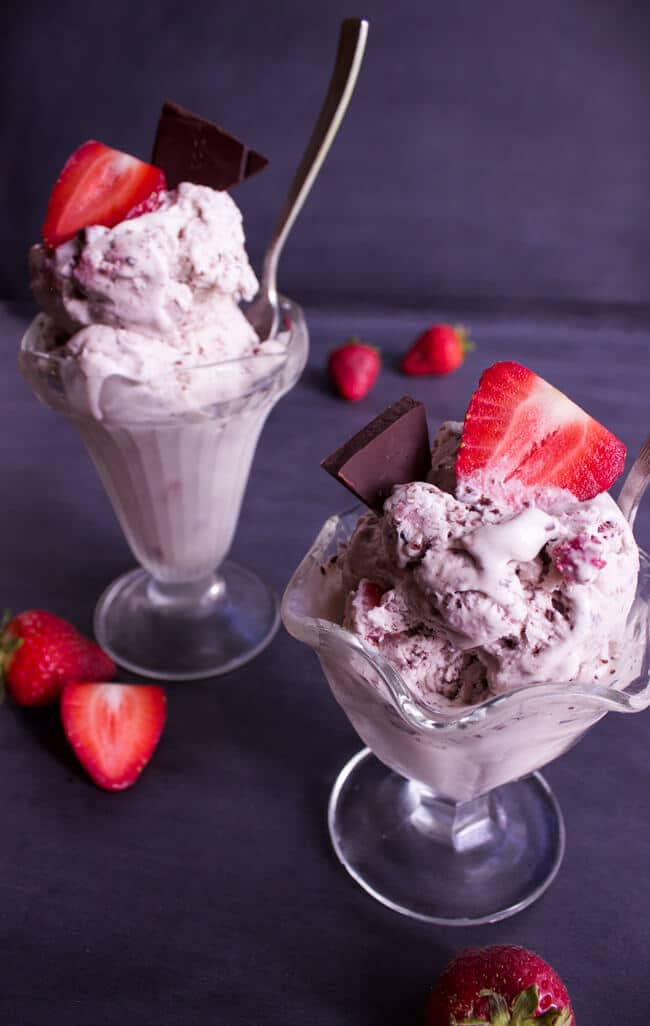 No Churn Red Wine Strawberry and Salted Dark Chocolate Ice Cream in clear glass dishes topped with strawberries.