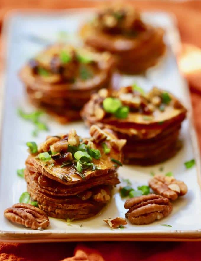 Healthy Roasted Sweet Potato Stacks topped with toasted pecans, scallions, and rosemary