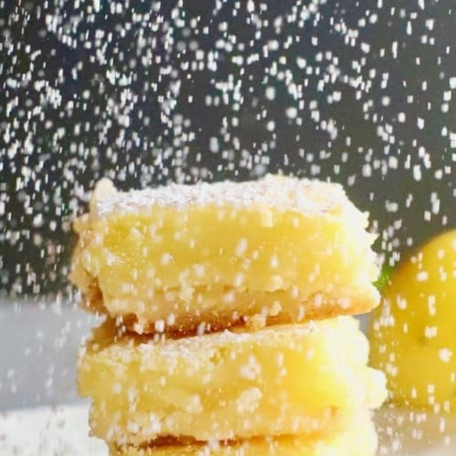 Confectioner's sugar being sifted on Luscious Southern Meyer Lemon Bars
