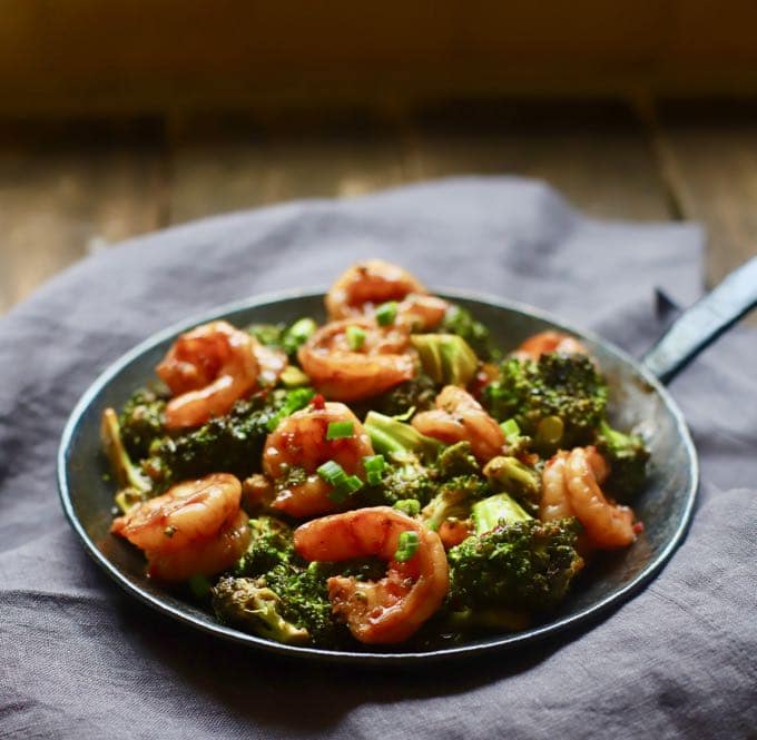 A hand-made black cast iron skillet full of Spicy Shrimp and Broccoli Stir Fry