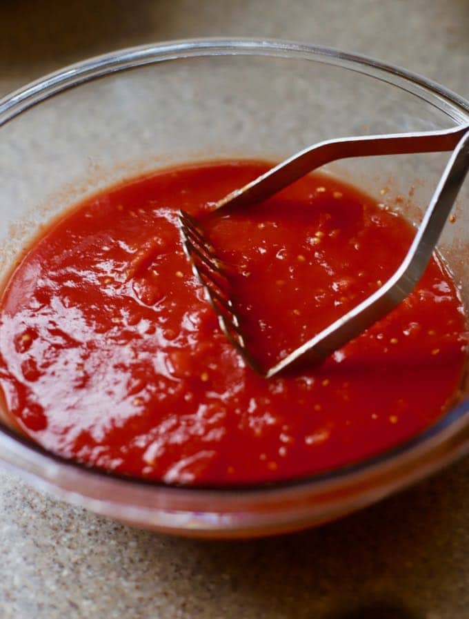 Canned tomatoes in a bowl for making Easy Stuffed Shells with Marinara Sauce 