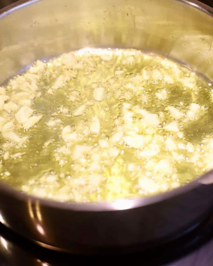 Cooking garlic in a pan for Easy Stuffed Shells with Marinara Sauce