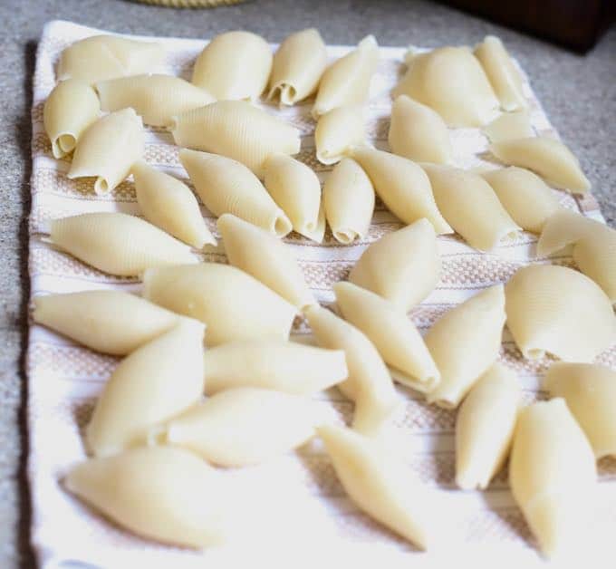 Draining cooked pasta shells for Easy Stuffed Shells with Marinara Sauce