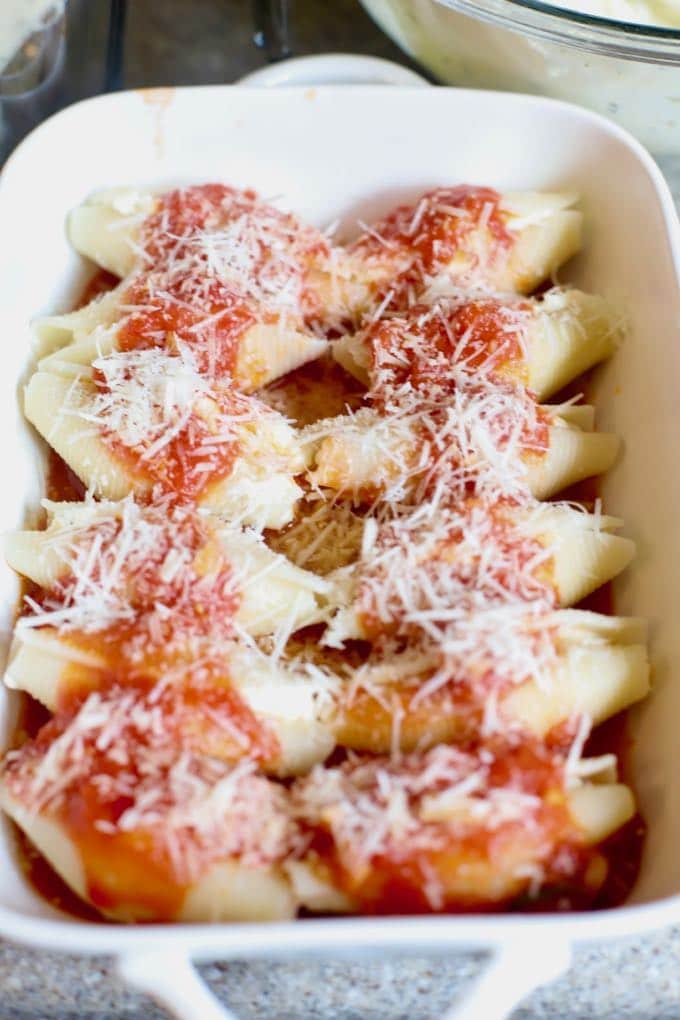 Stuffed pasta shells covered with marinara sauce and cheese and ready to bake for Easy Stuffed Shells with Marinara Sauce