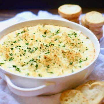 Hot and Cheesy Baked Shrimp Scampi Dip with toasted bread rounds ready for serving