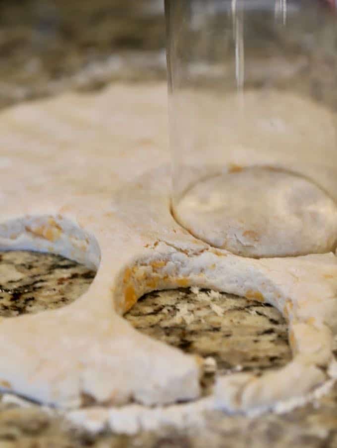 Using a glass to cut biscuits out of dough. 