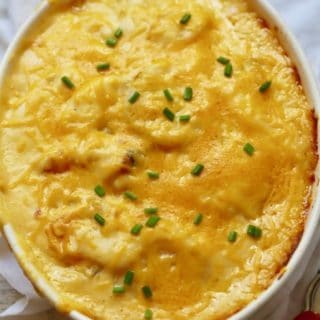 Hot out of the oven Southern Cheesy Scalloped Potatoes overflowing in a white baking dish