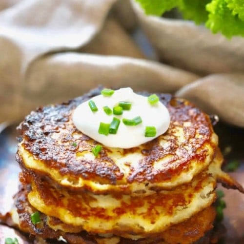 Traditional Irish Potato Boxty topped with sour cream and chives with green flowers in the background