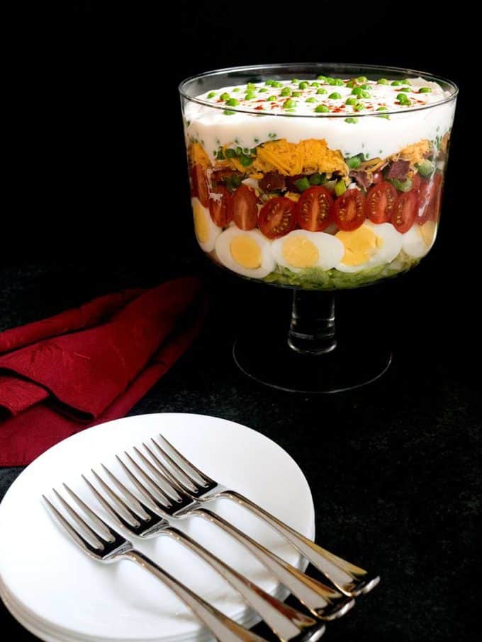 Classic Southern Seven Layer Salad with plates and forks ready to serve