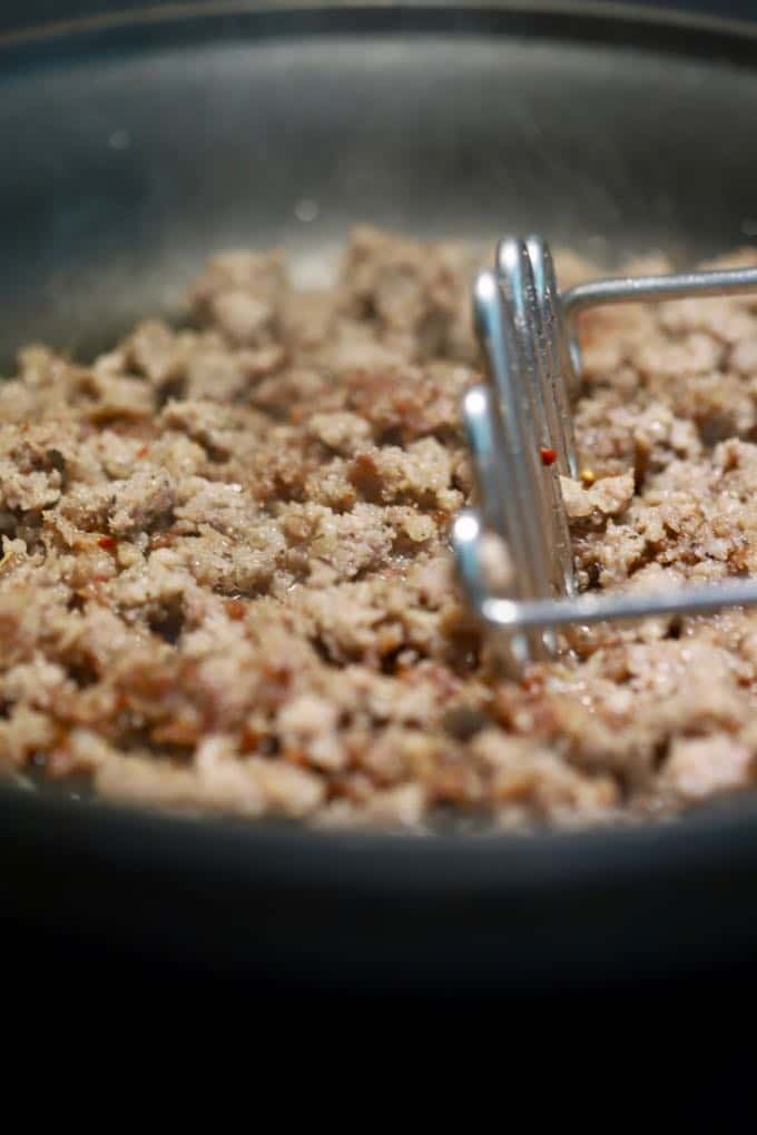 Cooking sausage in a skillet for Make Ahead Sausage and Grits Casserole