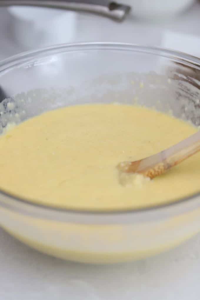 A mixture of eggs, milk, garlic and thyme in a bowl for Make Ahead Sausage and Grits Casserole