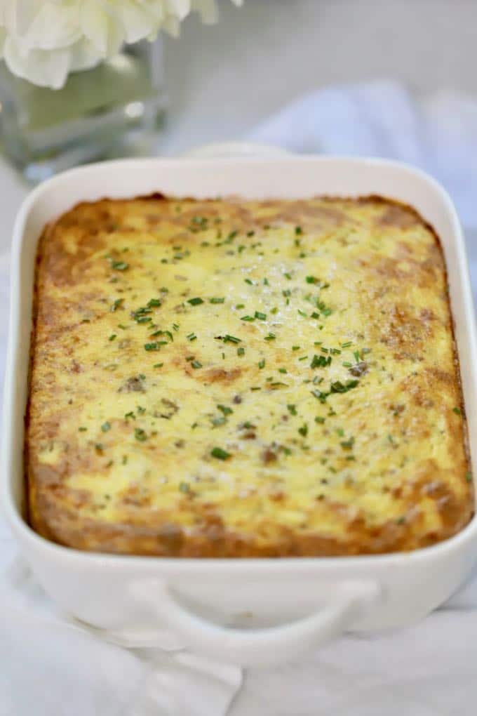 Make Ahead Sausage and Grits Casserole in a white baking dish right out of the oven