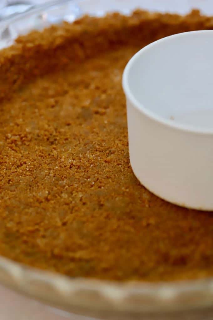 Smoothing out a mixture of cookie crumbs, butter and sugar for a pie crust for Red White and Blue Ice Cream dessert.