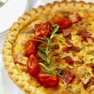 Roasted Tomato Quiche with Goat Cheese garnished with cherry tomatoes and fresh rosemary