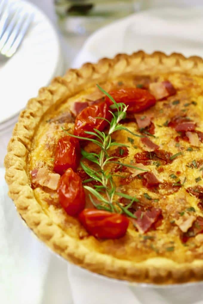 Roasted Tomato Quiche with Goat Cheese garnished with cherry tomatoes and fresh rosemary