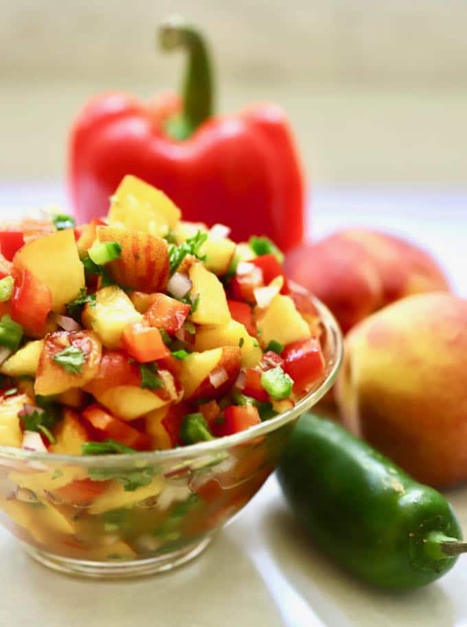 A glass bowl overflowing with Easy Southern Fresh Peach Salsa