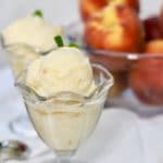 Two servings of Homemade Fresh Peach Ice Cream with peaches in the background