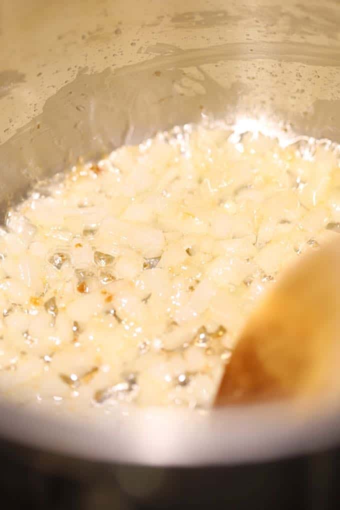 Cooking onion bits in a saucepan in olive oil.