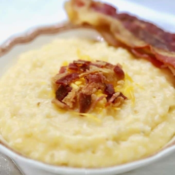 Southern Crockpot Easy Cheesy Grits topped with bacon in a bowl