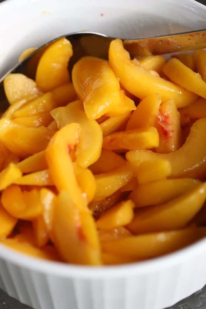 A large bowl of fresh peach slices. 