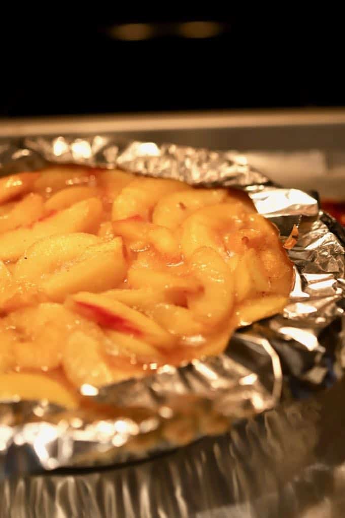 Strips of aluminum foil cover the outside edges of a pie crust to keep it from burning.