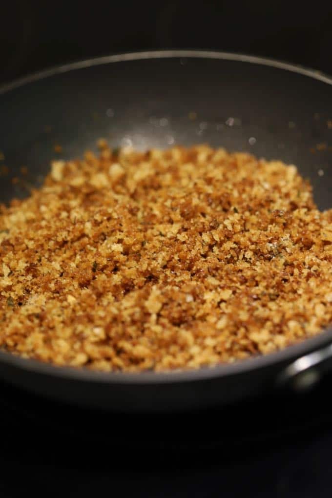 Panko breadcrumbs toasting in a skillet.