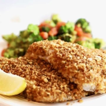 Easy Crispy Oven Baked Grouper fillets on a plate with broccoli and tomatoes