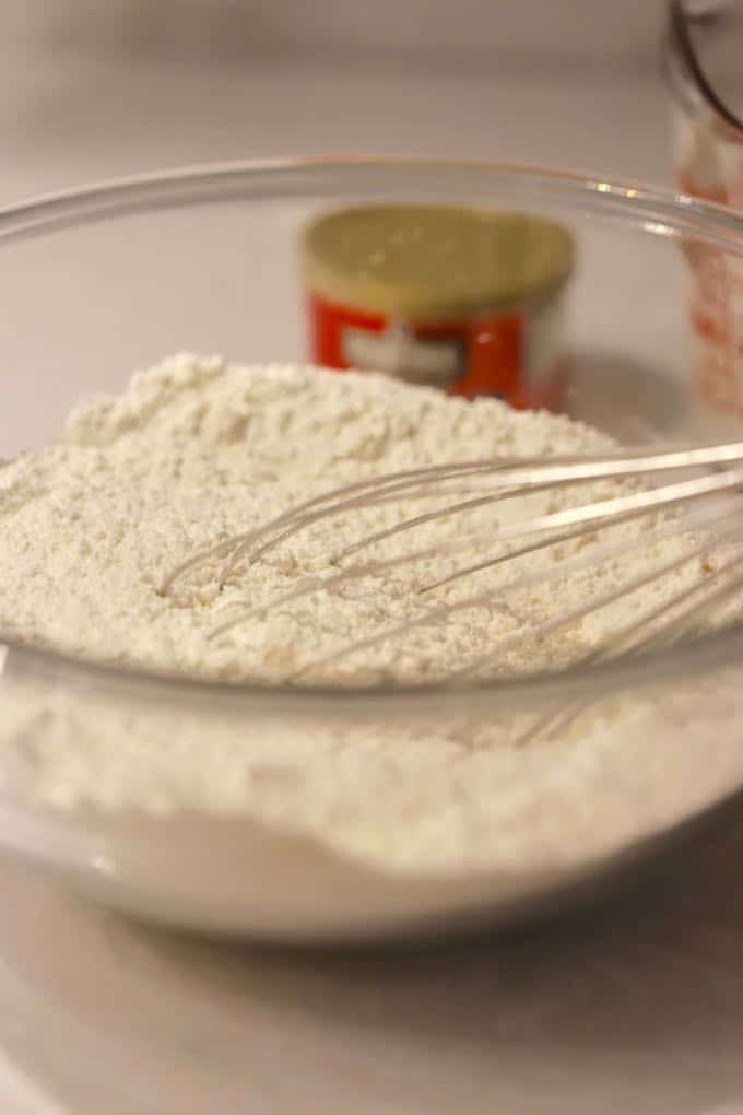 Mixing flour, baking powder, sugar, and salt for Easy Orange Cinnamon Rolls