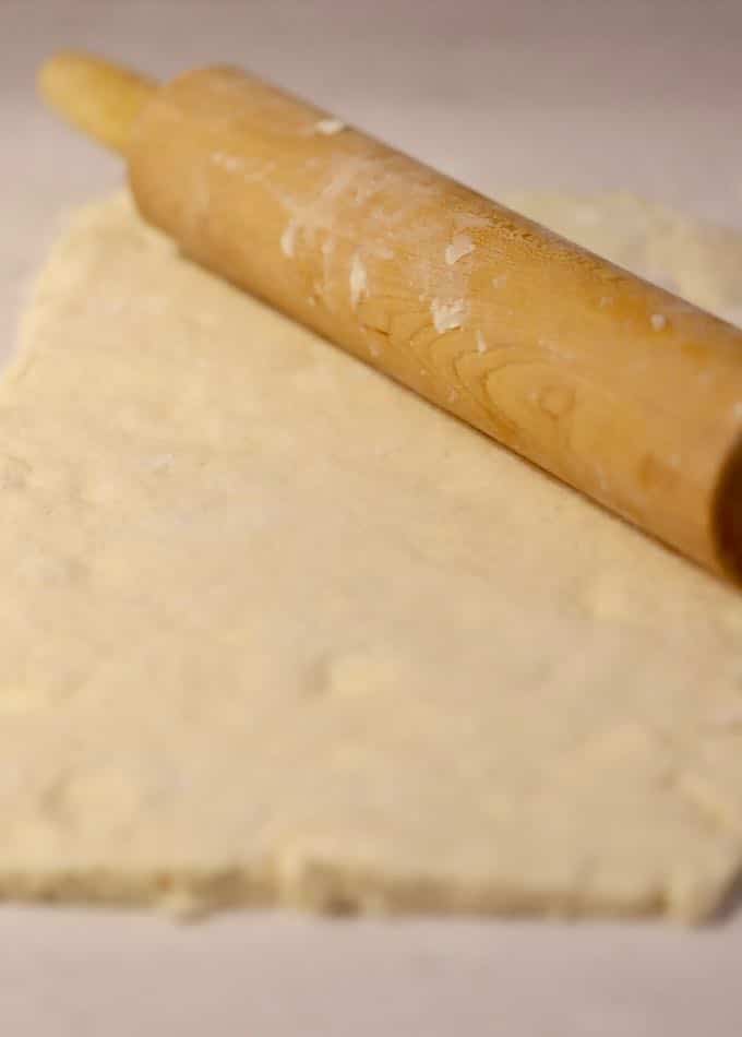 Cinnamon roll dough rolled out with a rolling pin. 