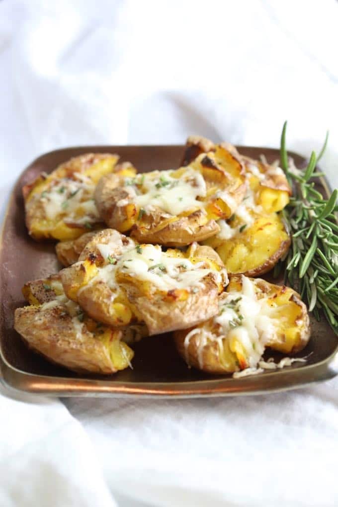 Easy Parmesan Truffle Smashed Potatoes garnished with a sprig of rosemary