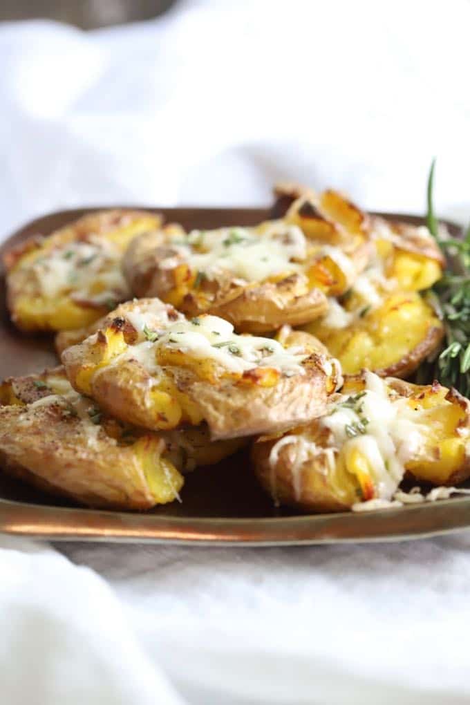 Easy Parmesan Truffle Smashed Potatoes on a bronze plate ready to serve.