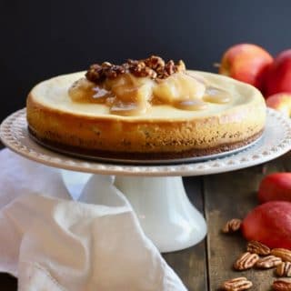 Apple Pie Cheesecake with Caramel Topping on a cake stand