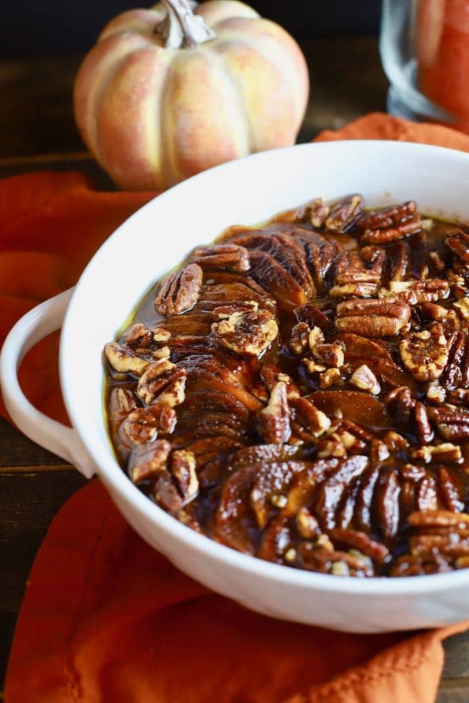 Candied Sweet Potatoes topped with pecans on an orange napkin. 