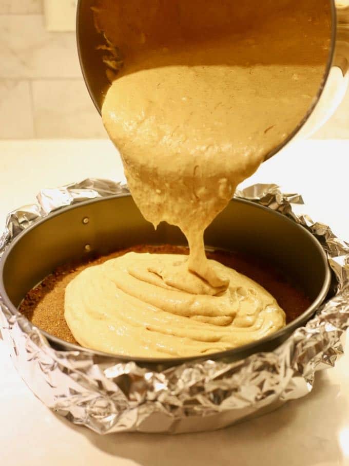 Pouring pumpkin cheesecake batter into a gingersnap crustPumpkin Cheesecake with Gingersnap Crust