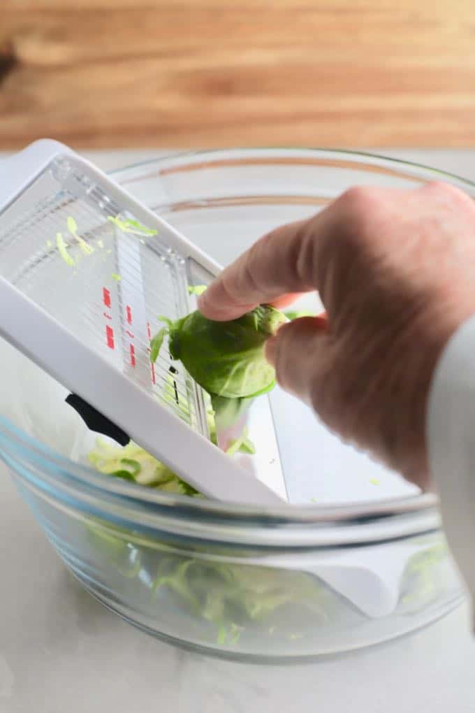 Using a mandoline to slice Brussels Sprouts for Brussels Sprout Salad with Citrus Vinaigrette