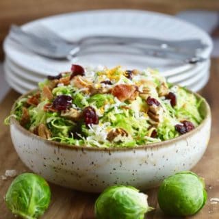 Brussel Sprouts Salad with Citrus Vinaigrette topped with bacon and parmesan cheese.