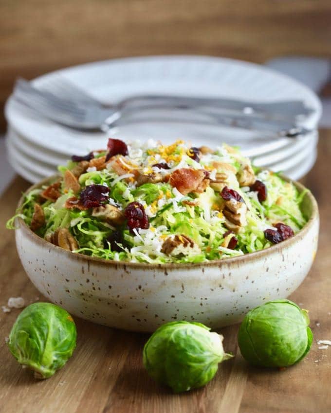 Brussel Sprouts Salad with Citrus Vinaigrette topped with bacon and parmesan cheese.