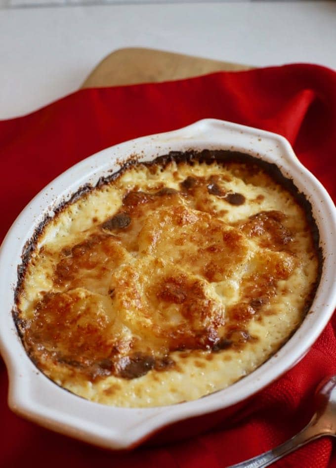 Easy Parmesan Potatoes Au Gratin in a gratin dish on a red napkin.