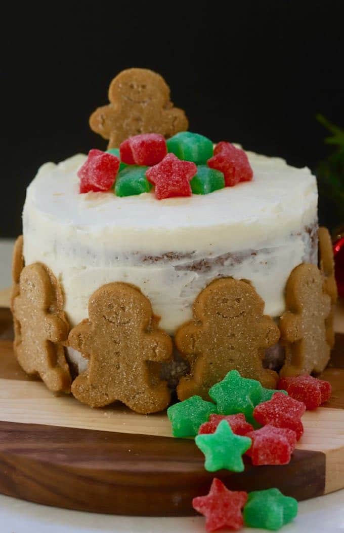 Gingerbread Cake with Cream Cheese Icing surrounded by gingerbread cookies