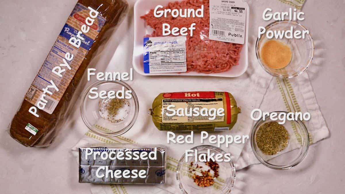 Ground beef, sausage, and party rye bread on a counter. 